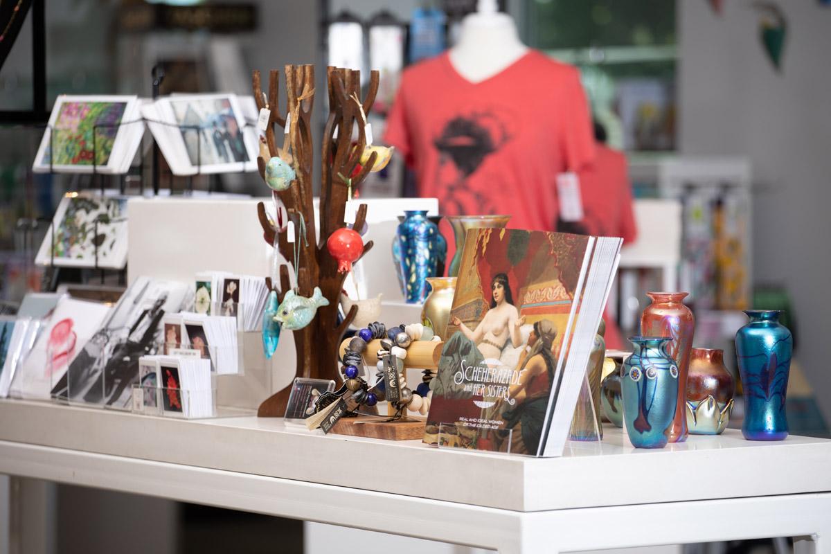 A table of postcards, ornaments, and exhibition-related books and artwork in the Museum store.